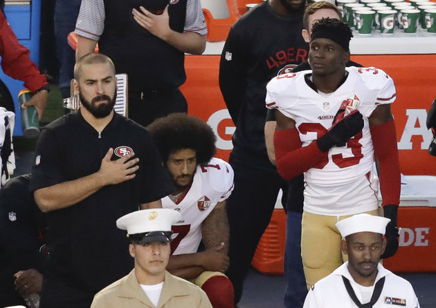Colin Kaepernick middle) kneeling in protest at the US national anthem.