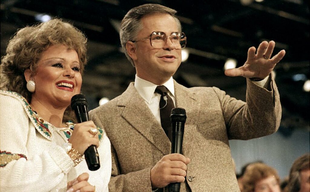 Jim Bakker during a PTL broadcast with his wife Tammy Faye, 1986