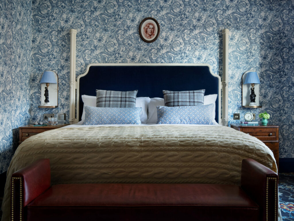 A bedroom with an Oscar Wilde portrait above it