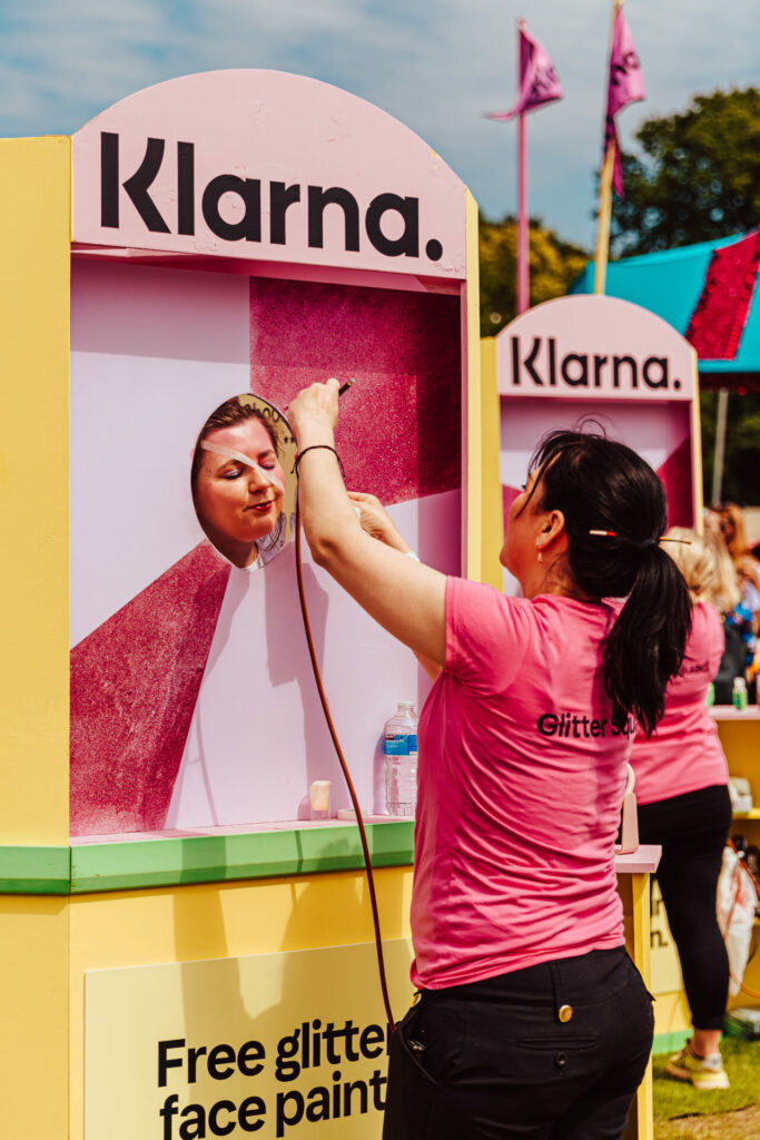 A Mighty Hoopla attendee gets their face painted in a Klarna booth