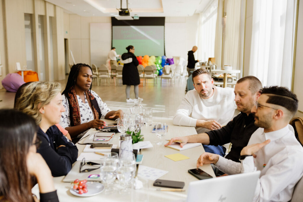 A group of people sit around a table to have a discussion.