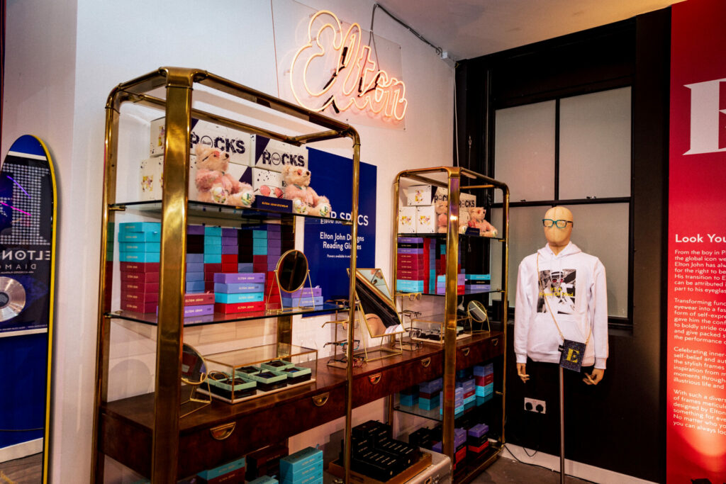 A display case containing glasses and clothes