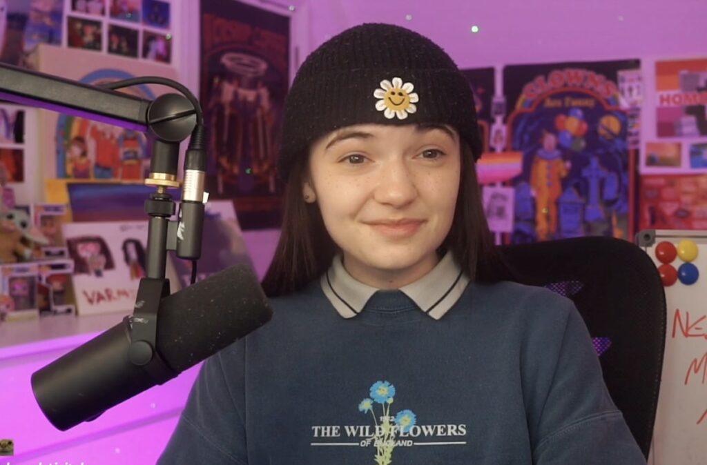 Aimsey wearing a blue jumper and black beanie at their streaming set up