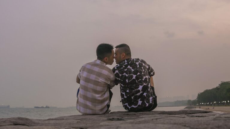 Image from Straight Best Friend: two men leaning into kiss at the beach.