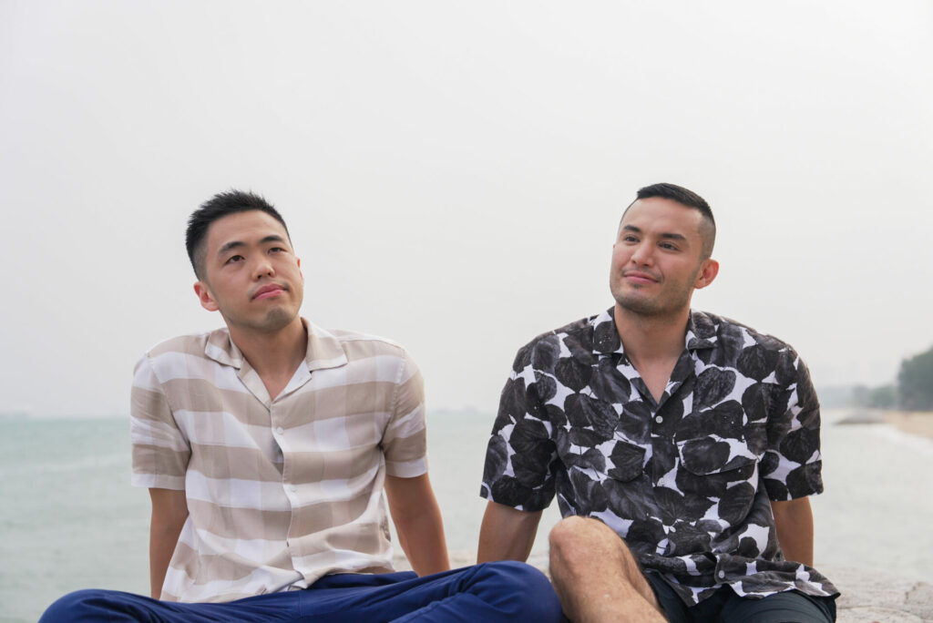 Image from Straight Best Friend: two men sat next to each other at the beach.