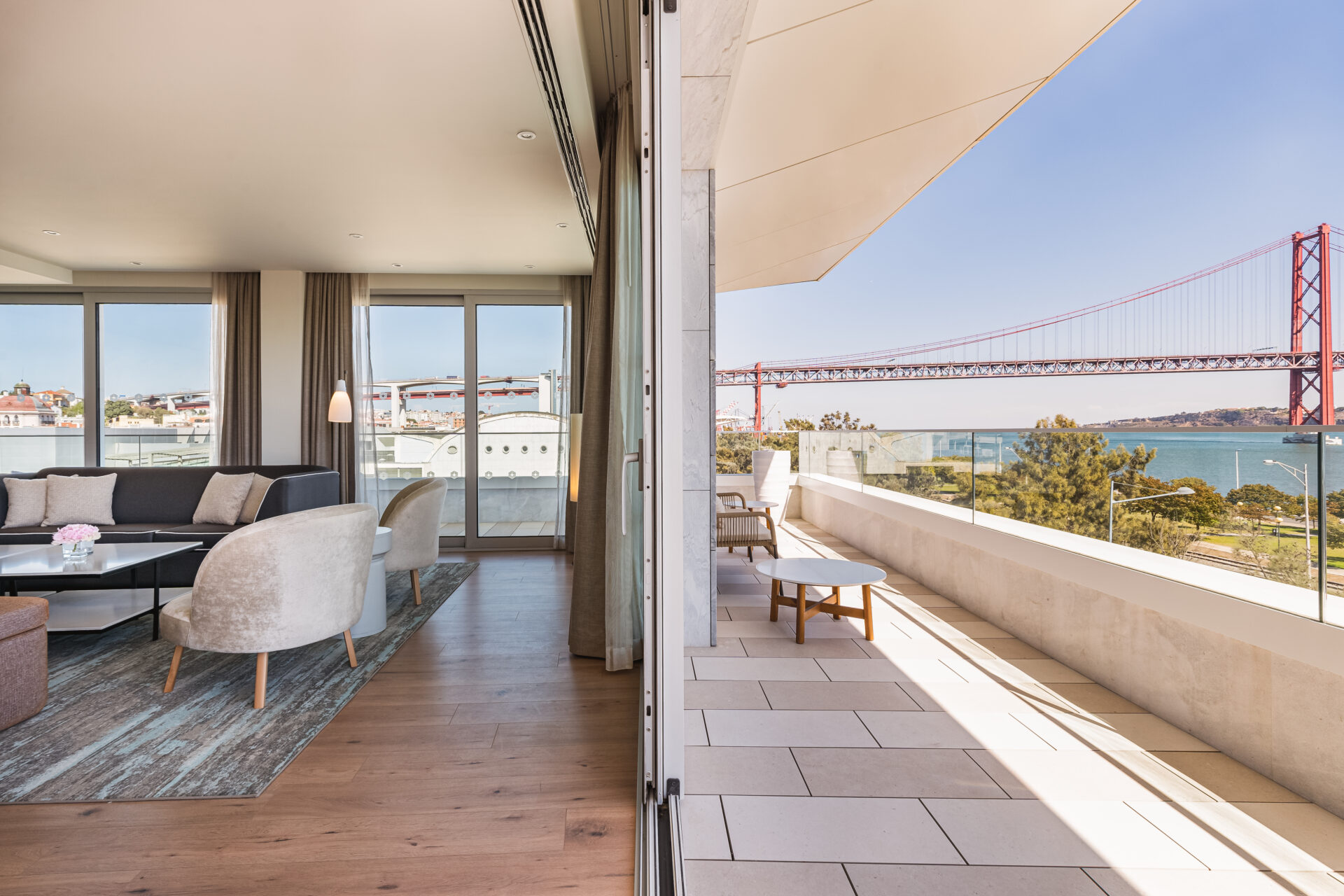 View of a hotel room with a balcony overlooking a bridge