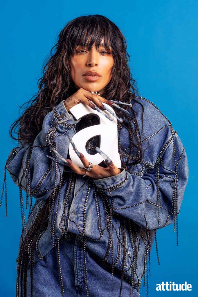 Loreen poses with her Attitude award trophy. She's wearing a blue denim jacket.