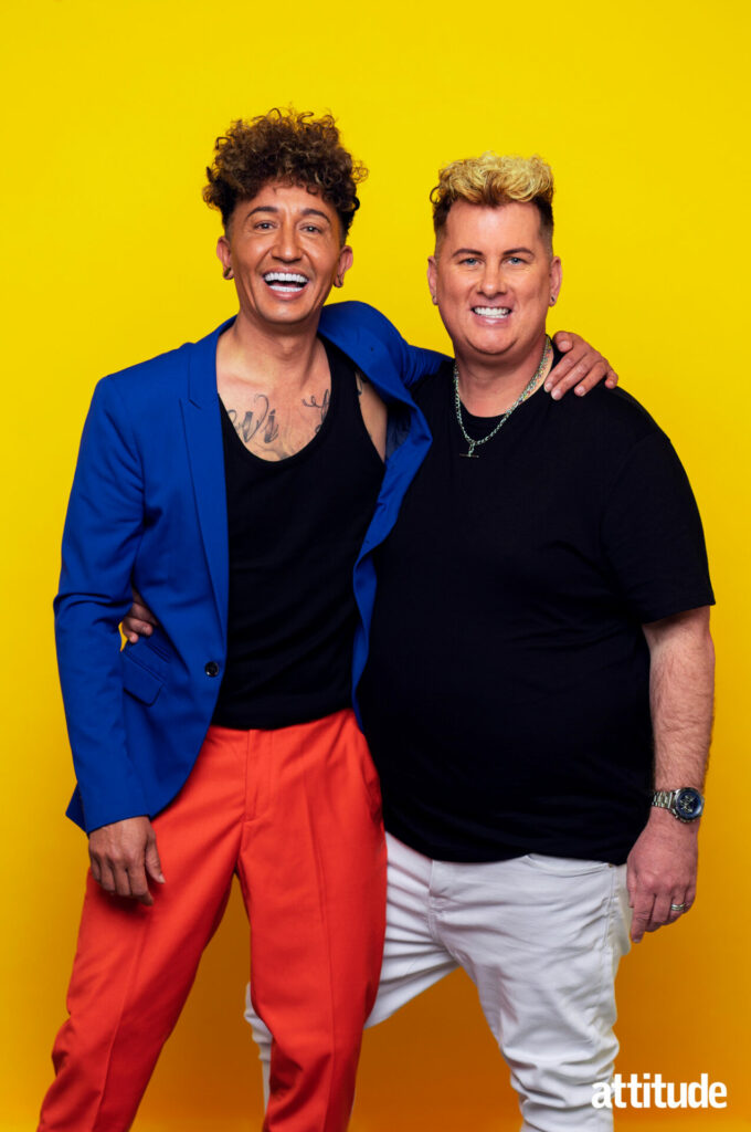 Same-sex couple Michael and Paul posing against a yellow background.