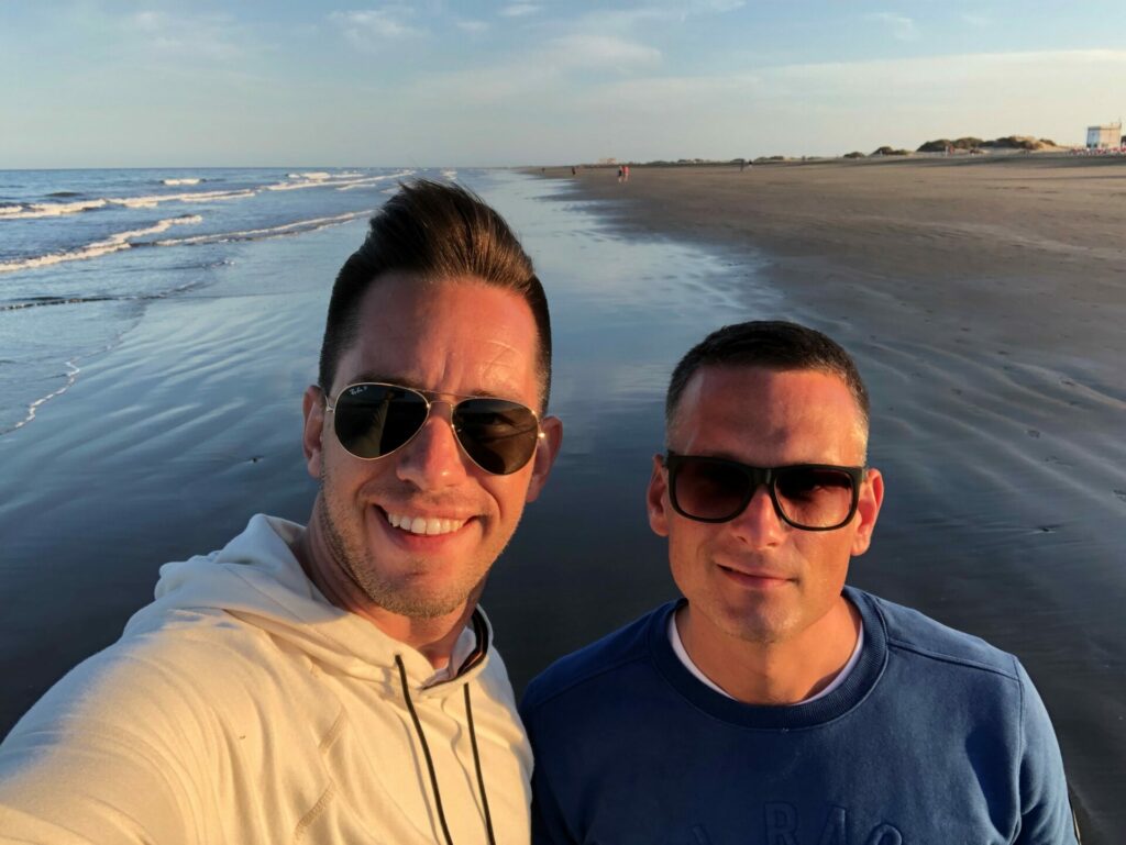 Two men wearing sunglasses look into the camera