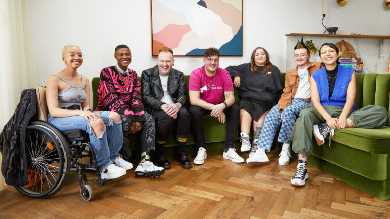 A group of people sit together and look into the camera smiling