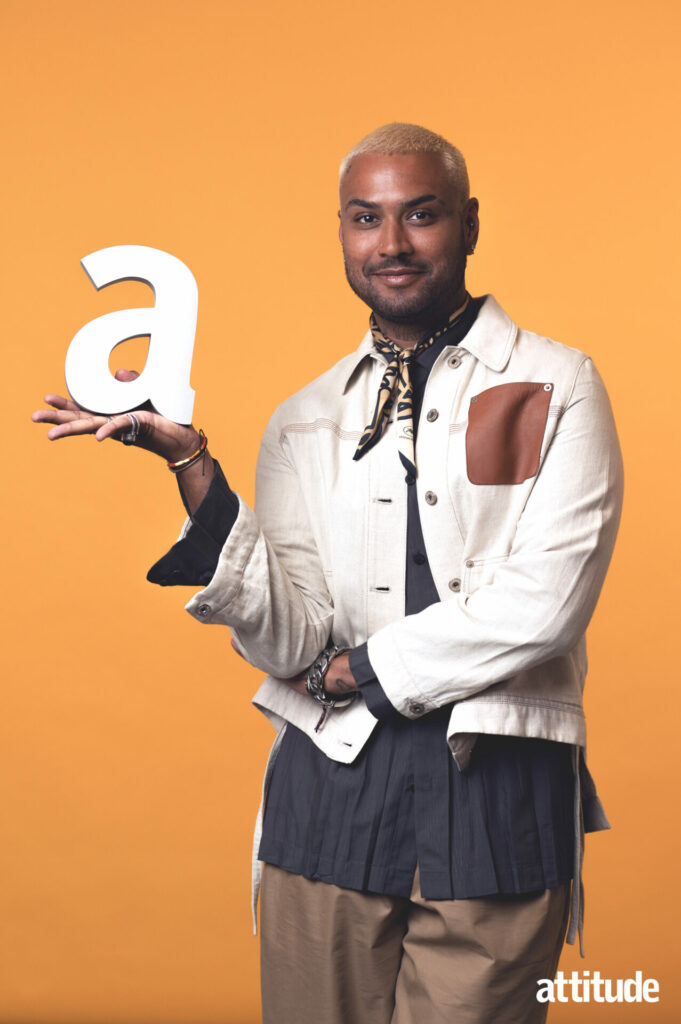 Ryan holding the Attitude award trophy with a bandana scarf and white overshirt against a mustard background.