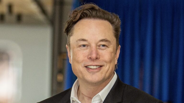 Elon Musk in a suit looking past the camera