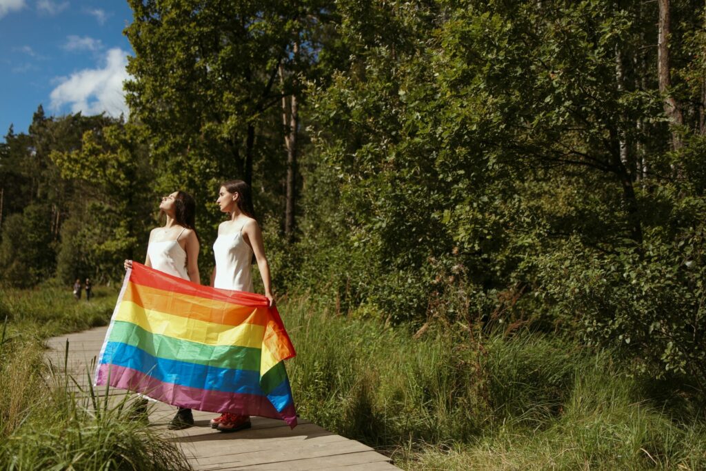 A queer female couple with a pride flag