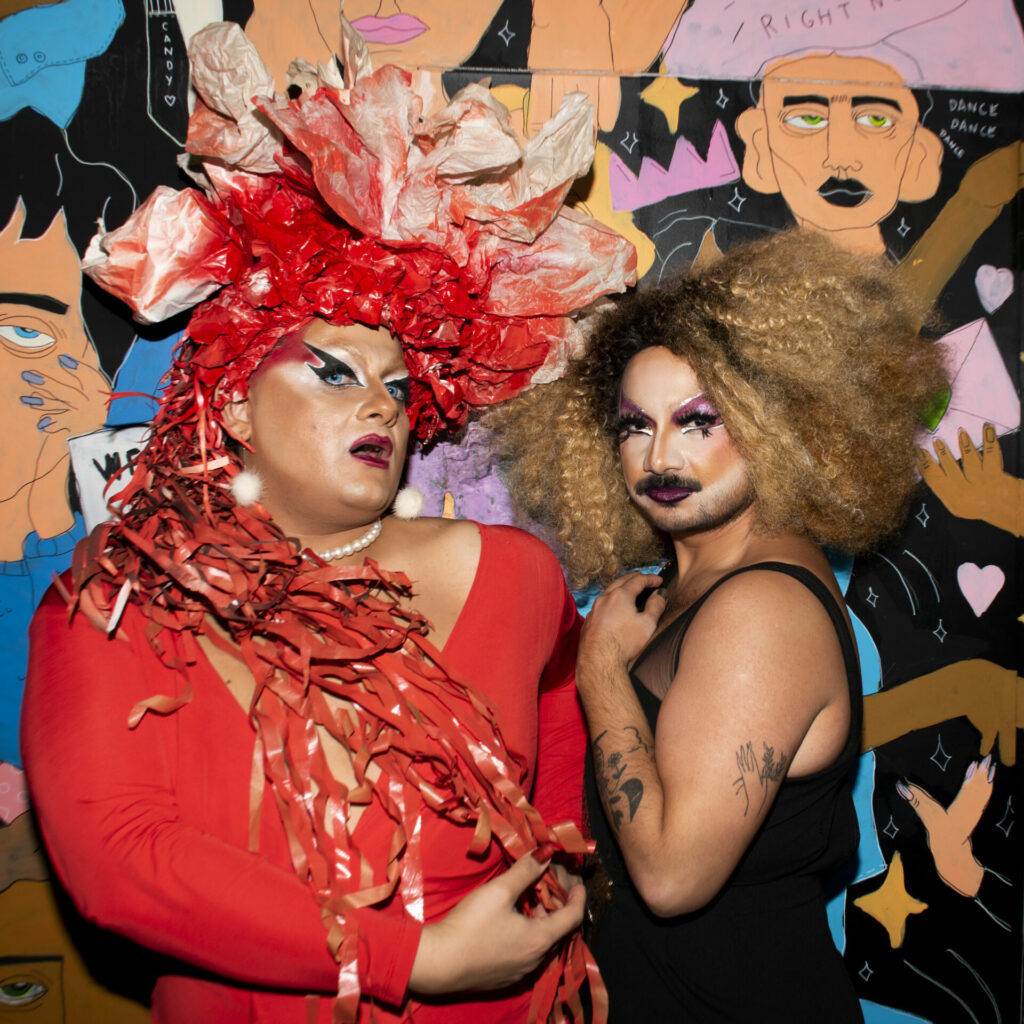 Two drag queens pose for the camera