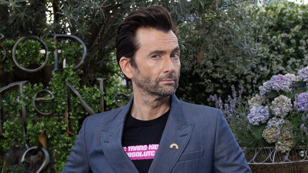 David Tennant in a dark blue suit in front of the Good Omens press event