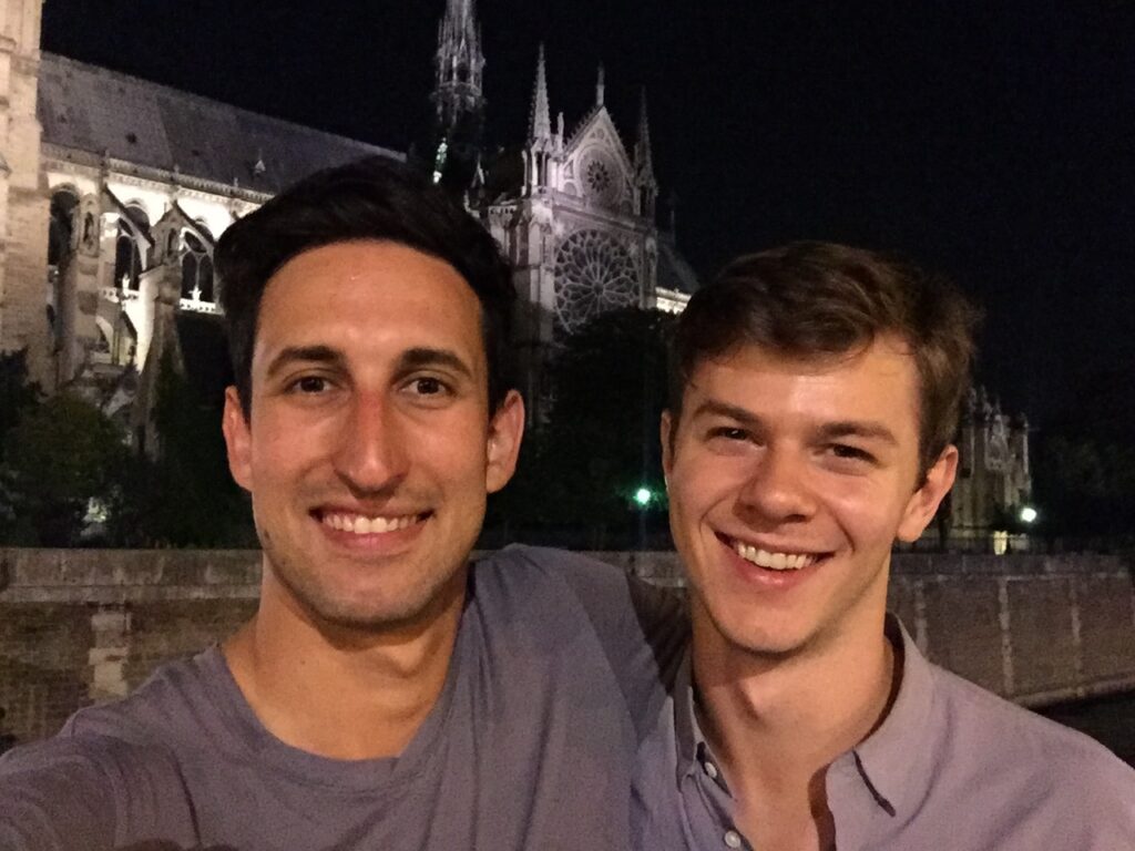 Two men smile into the camera