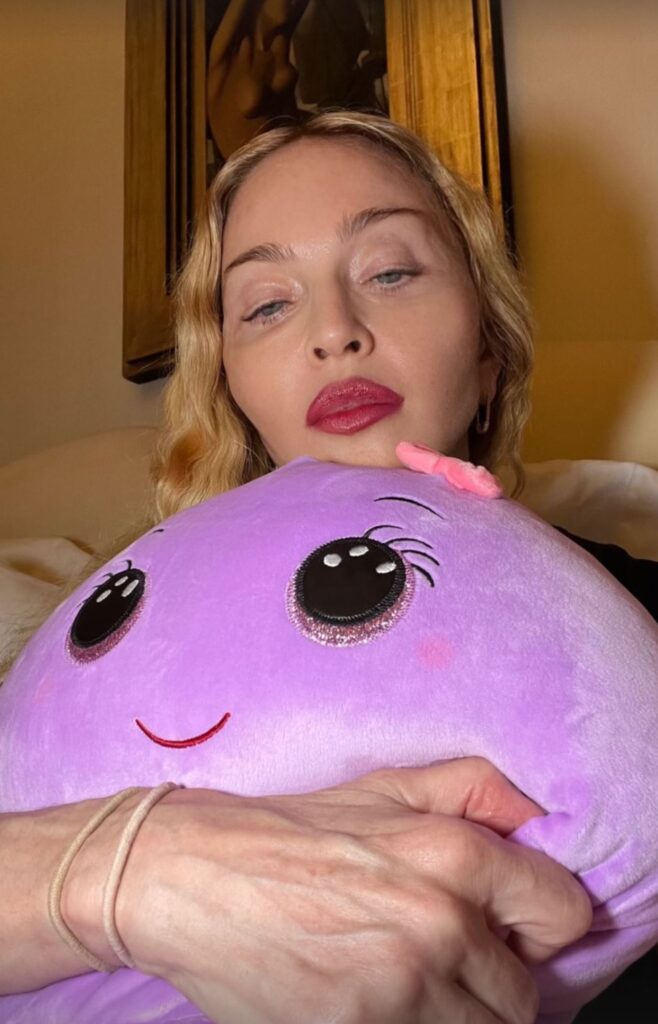 Madonna holding a purple plush toy