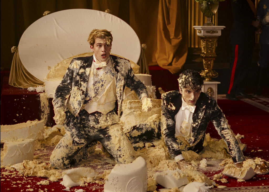 Nicholas Galitzine and Taylor Zakhar Perez covered in cake in Red White and Royal Blue.