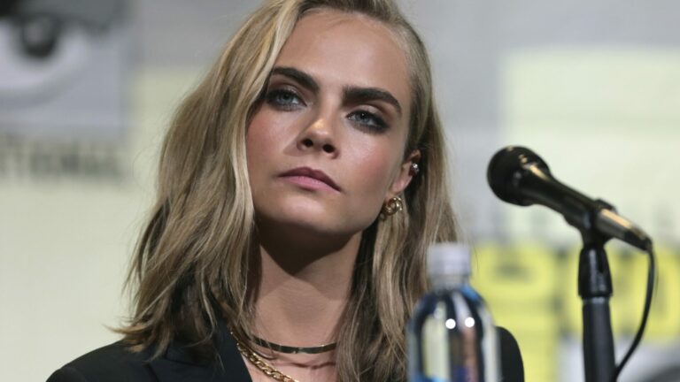 Cara Delevingne sits in front of a microphone