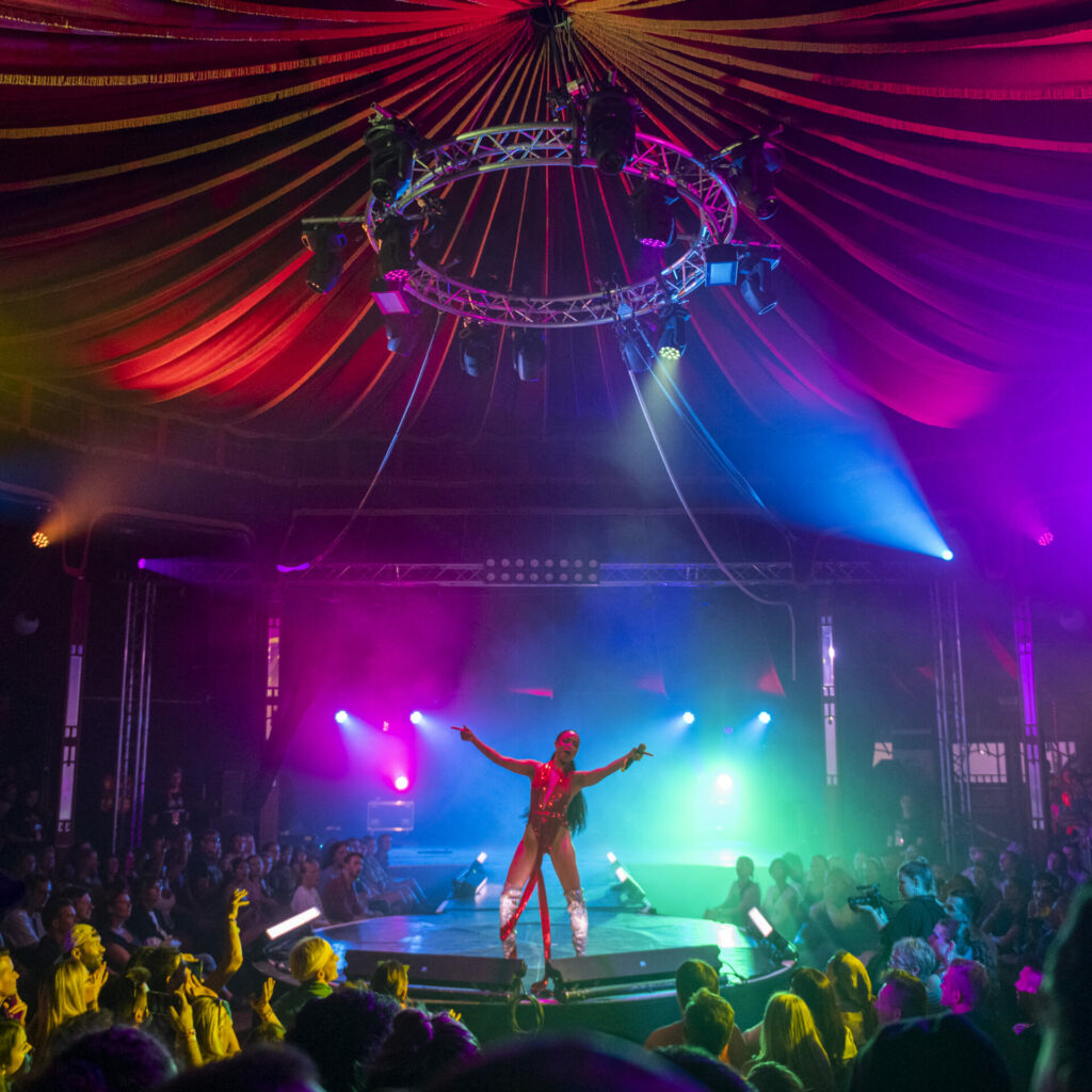 Performer at Sziget festival, in the middle of a circle stage surrounded by clapping crowd.