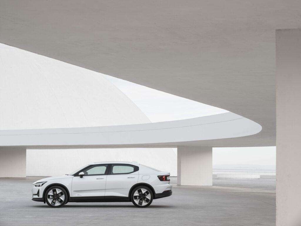 A white car sits inside a white building