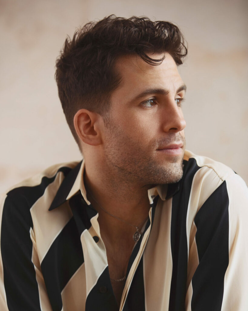 Headshot of a man wearing a striped shirt looking off to the side