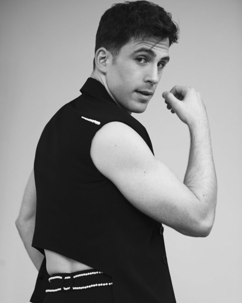 Black and white image of a man in a vest top looking back towards the camera