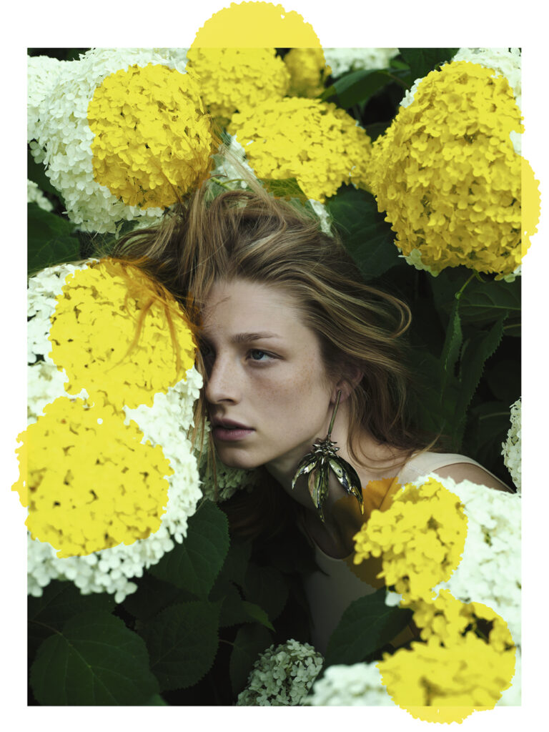 Hunter Schafer with her hair and face against flowers