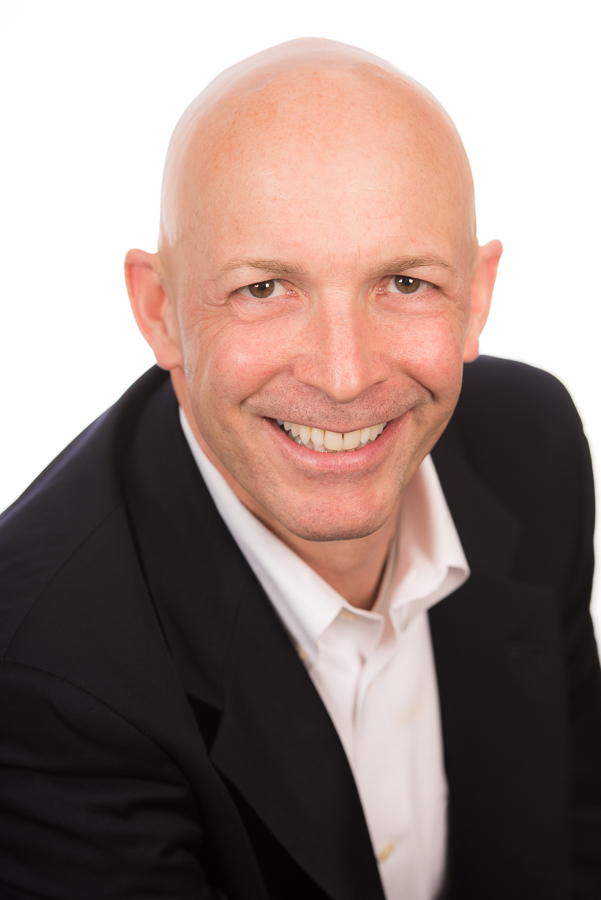 Headshot of a man with a black jacket and white shirt