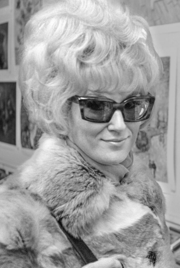 Dusty Springfield wearing large sunglasses and a fur coat in the 1960s
