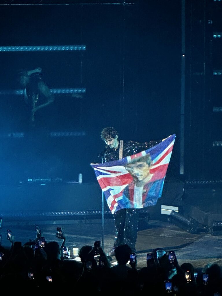 Omar Apollo waves a Union Jack flag with his face on