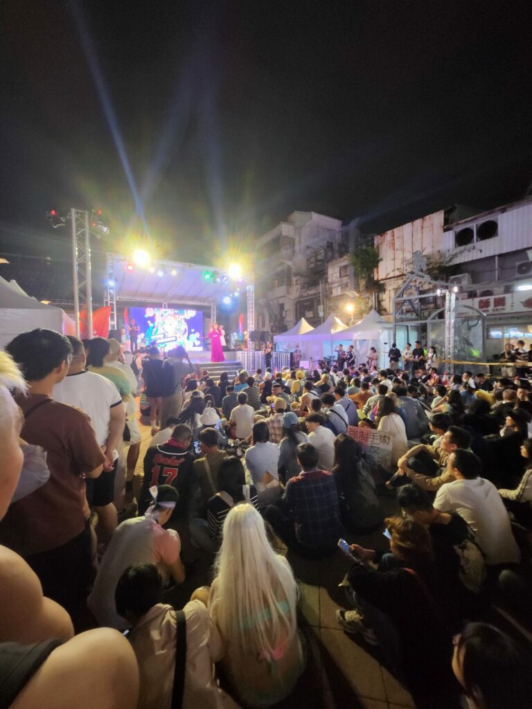 Crowds of people in front of a stage at nighttime