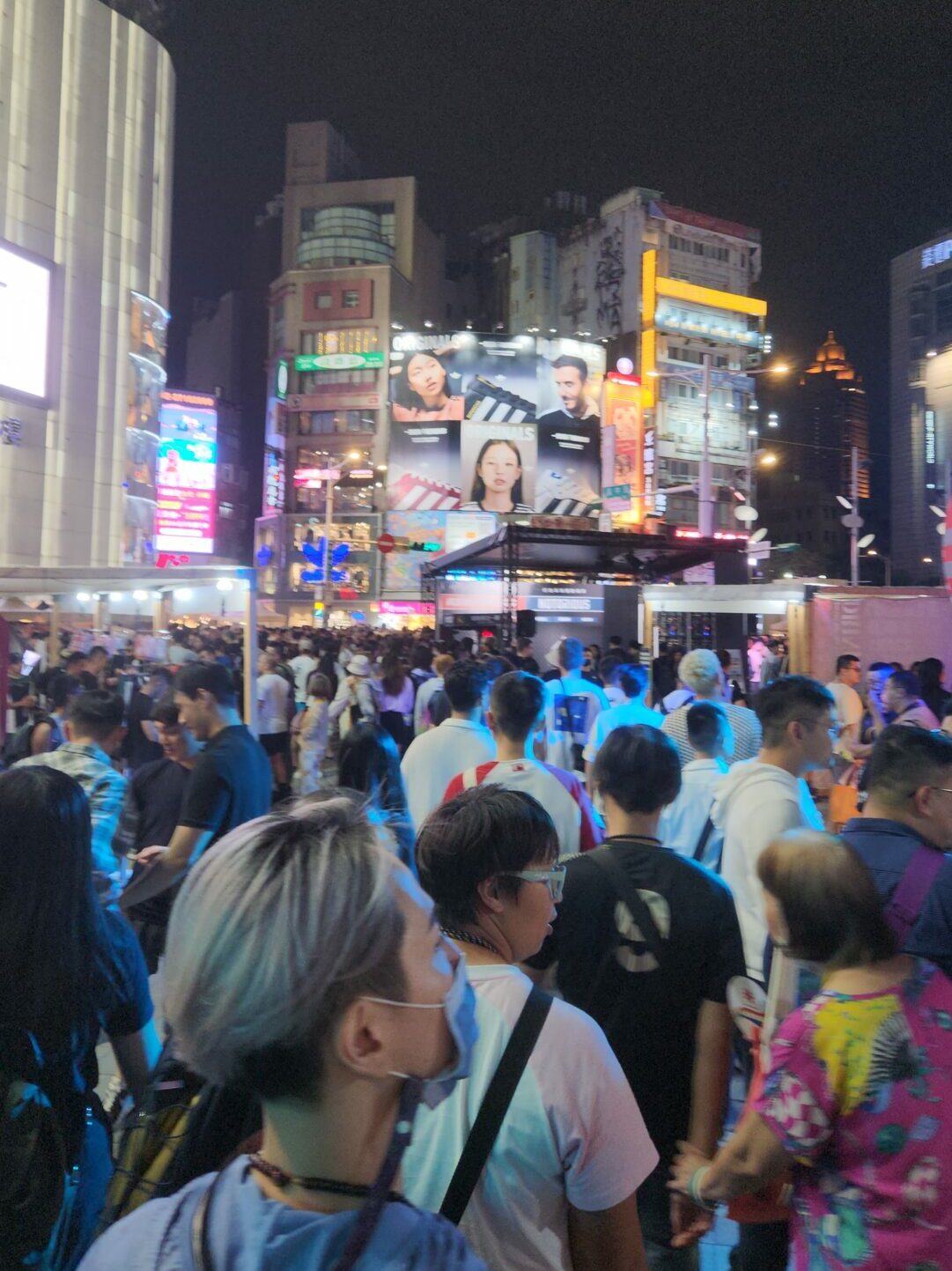 Crowds attend the Trans March event with skyscrapers in the background