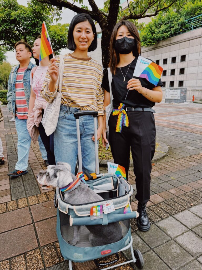 A couple of people with a dog in a pram at the Taiwan Pride 2023 parade