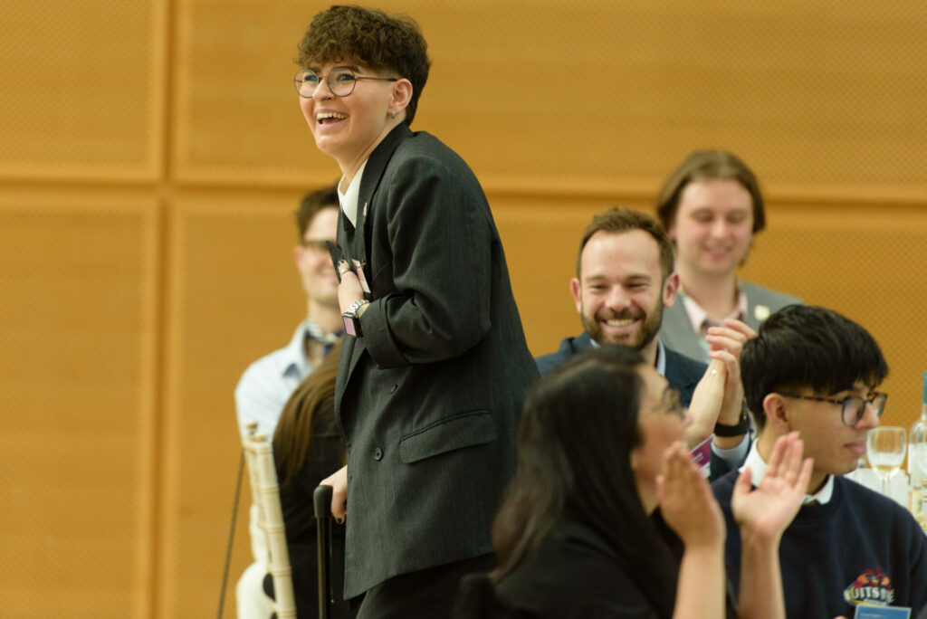 A person stands up  to receive an award