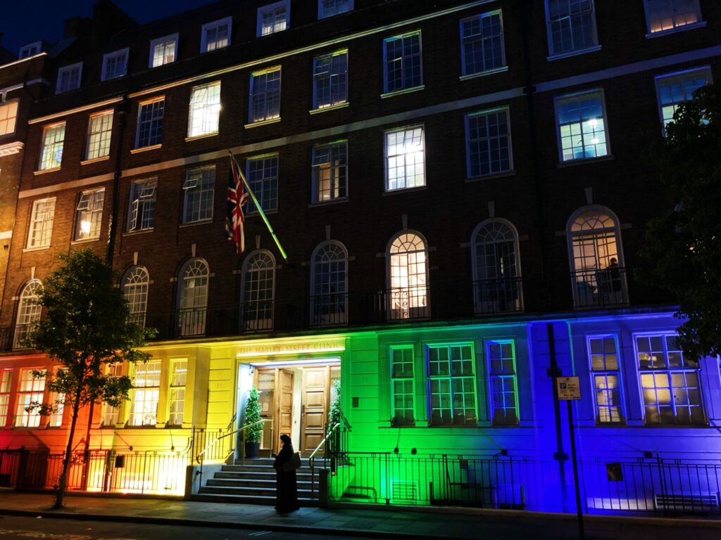A London terraced building at night covered by rainbow coloured lights