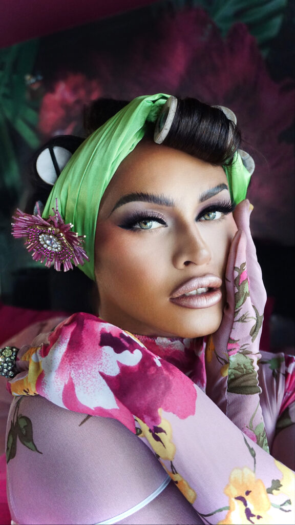 Close up of Sasha Colby wearing a green rag in her hair and rollers