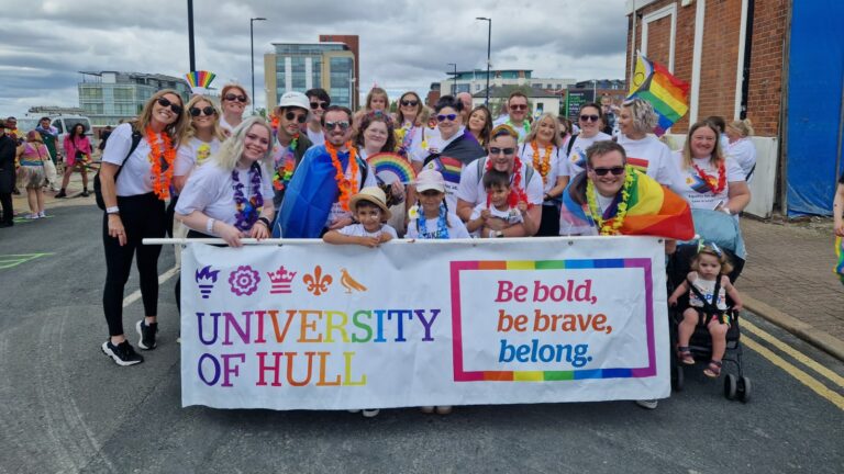 Group of people hold a University of Hull Pride banner on the street