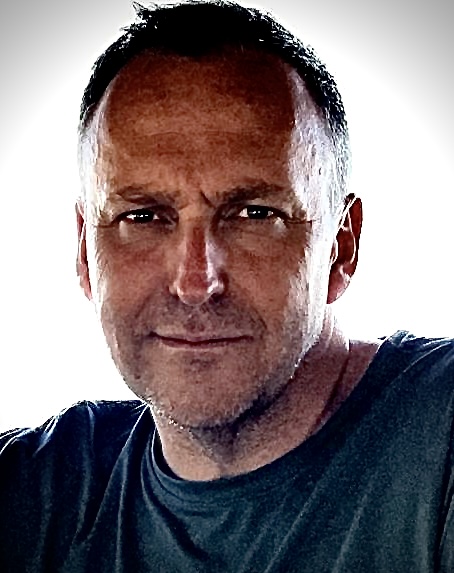 Portrait shot of a man smiling wearing a blue T-shirt