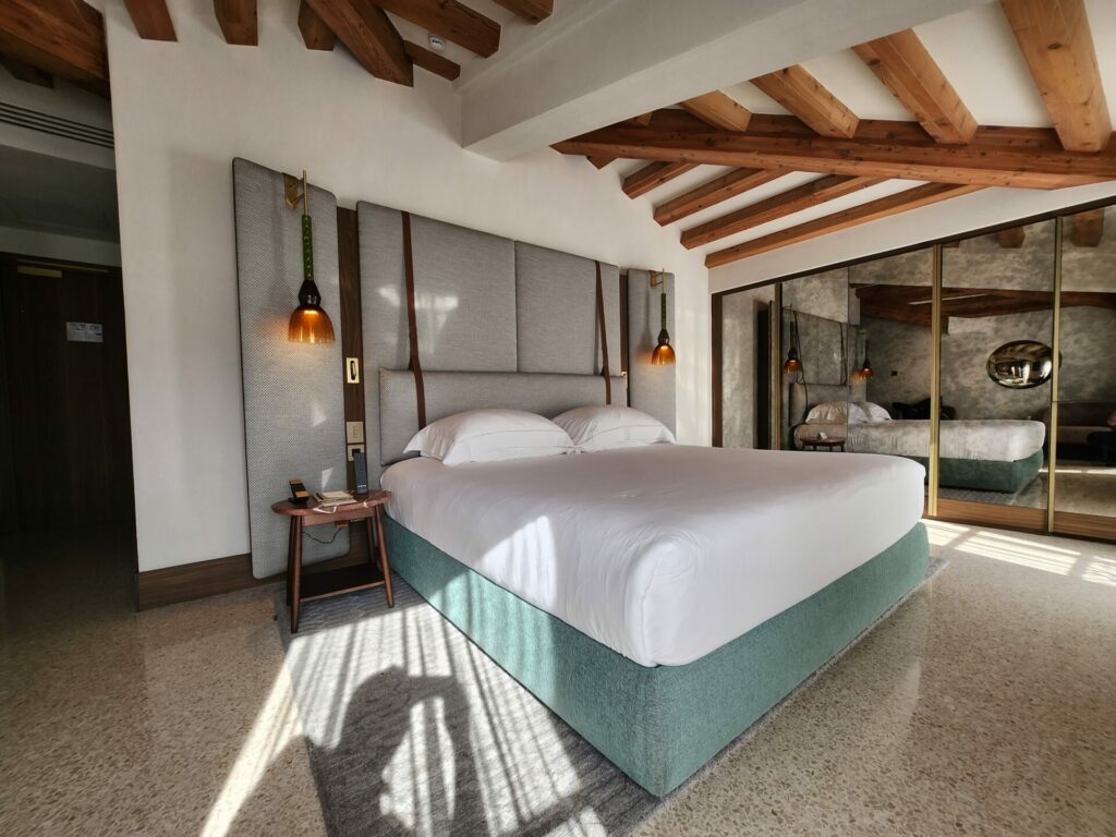 Hotel bedroom with white ceiling and wooden beams