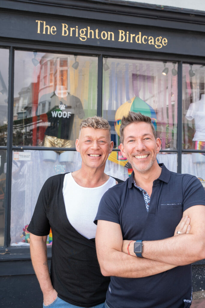 Two men stand outside the Brighton Birdcage store smiling