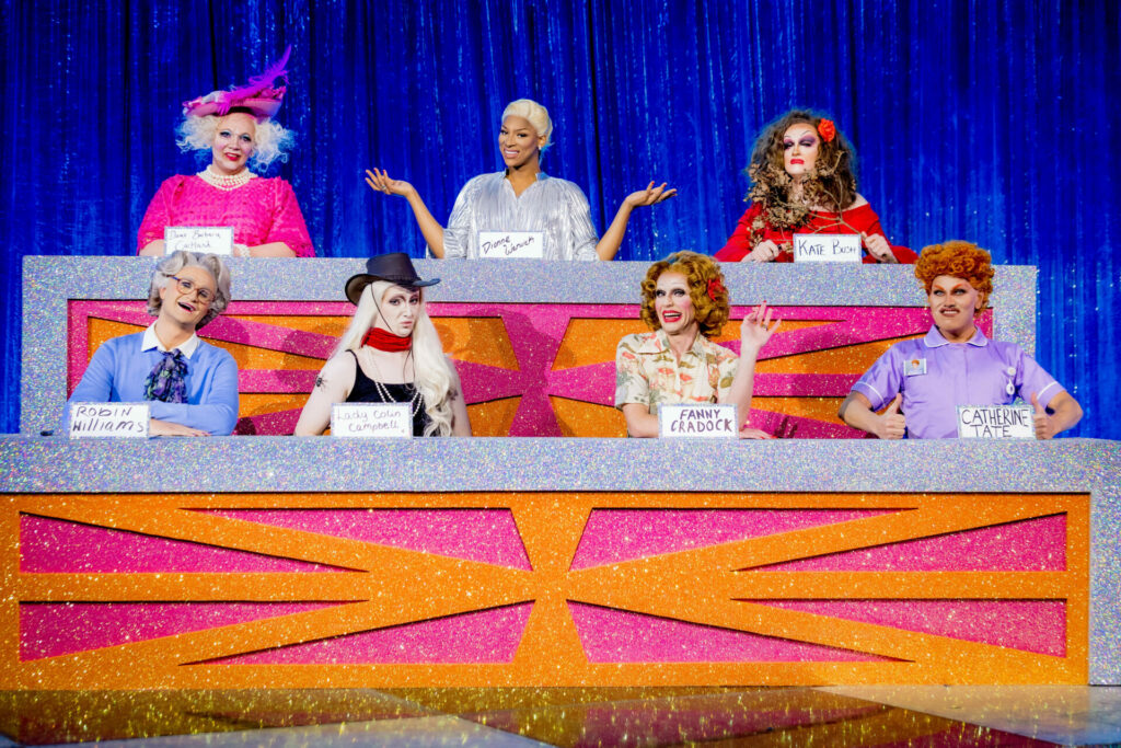 A group of drag queens in character for the Snatch Game challenge on Drag Race UK