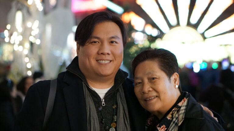 Mother and son stand together smiling