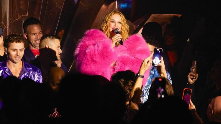 Kylie Minogue performs onstage wearing a pink outfit