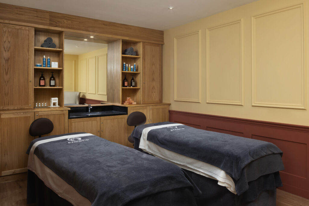 A massage treatment room with two beds