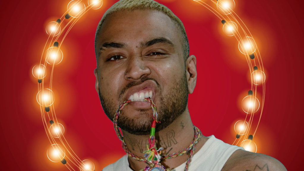 Close up shot of a man chewing his necklace with a cheeky pose against a stylised red background with a garland of white lights