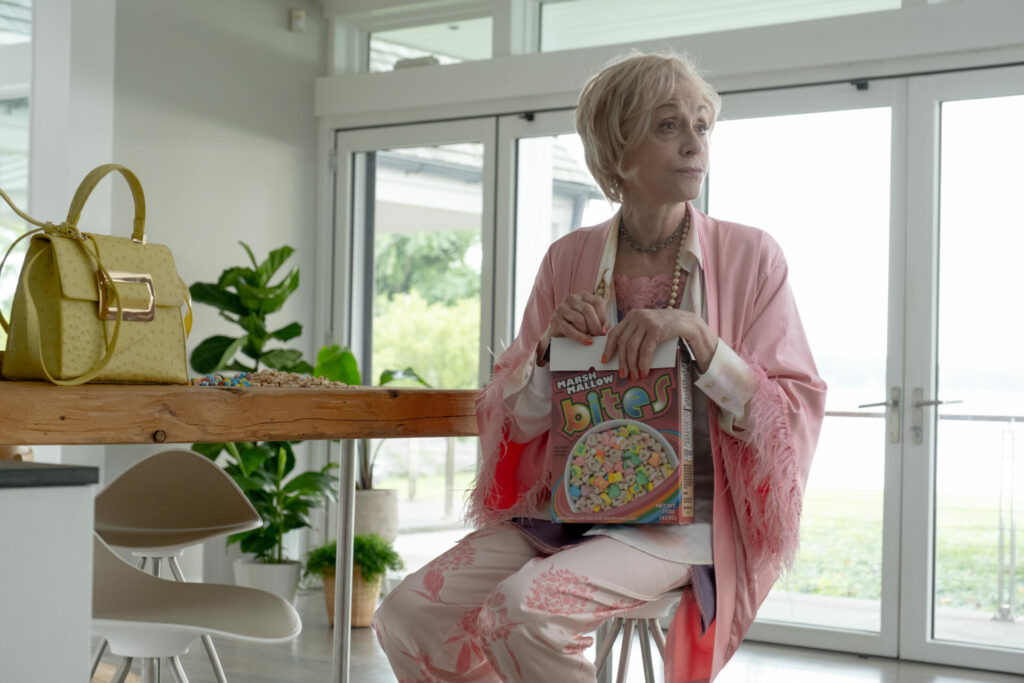 Still from Down Low showing Judith Light sitting on a chair wearing a pink cardigan