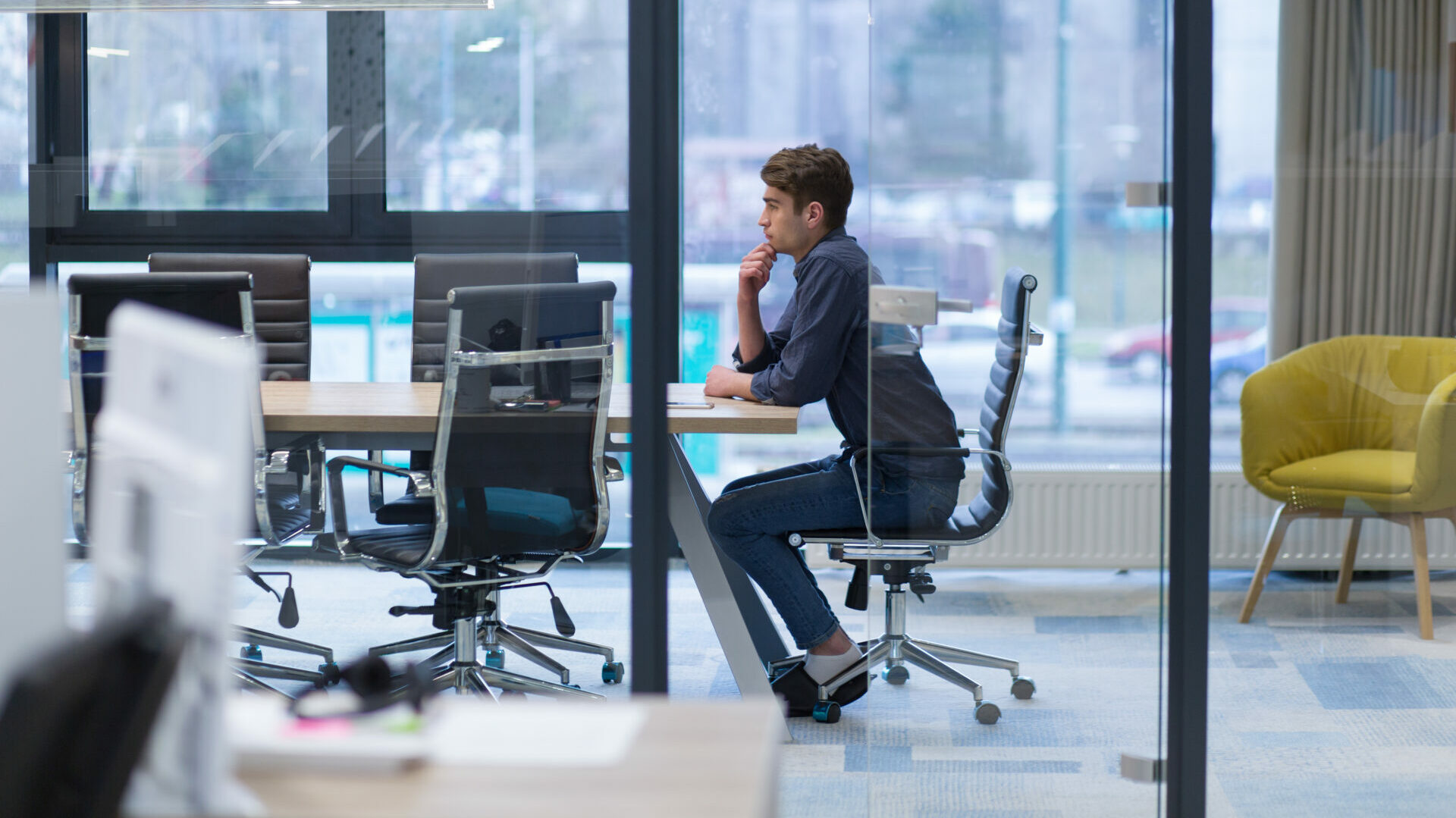 oung tired casual businessman relaxing at the desk in his office