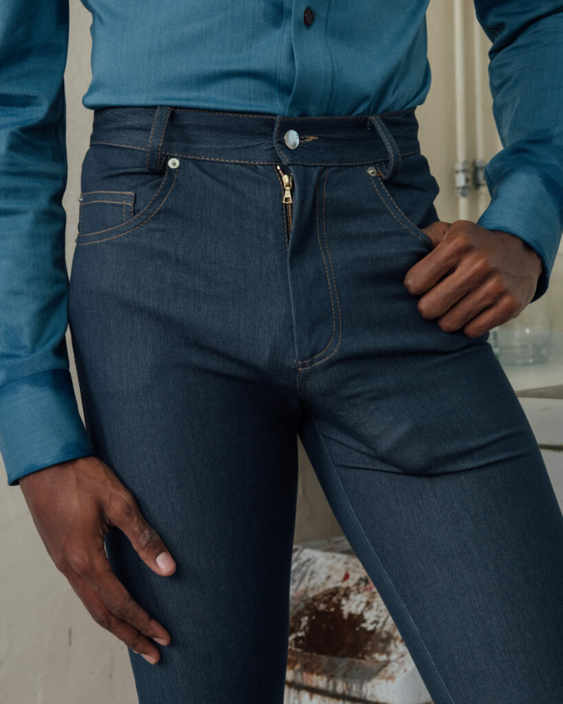 Close up of a man wearing blue denim jeans wtih a phallic prosthetic inside them