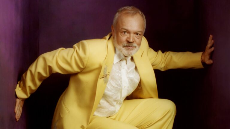 Graham Norton crouching in a yellow suit (Images: Attitude/Tom J. Johnson)